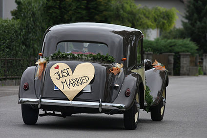 Classic car driving away with Just Married on back