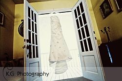 wedding dress hanging in doorway