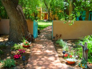 Hacienda del Sol Taos summer gardens, featuring New Mexican flowers, adobe wall garden, and turquoise gate