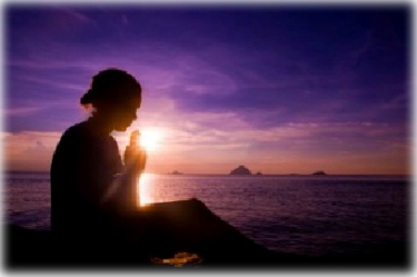 woman performing meditation and breath work next to the ocean