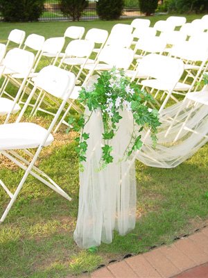 White folding chairs and aisle decorations for a wedding