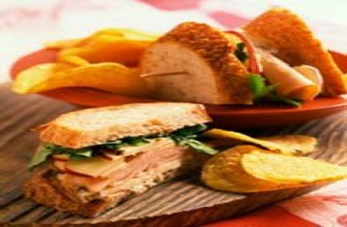 Ham and Cheese sandwich with chips and a pickle