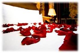 Silk rose petals on a bed at Berry Springs Lodge