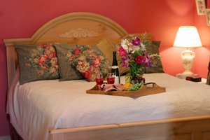 front view of bed with wine and flowers