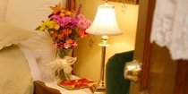 bed and chair with flowers on table